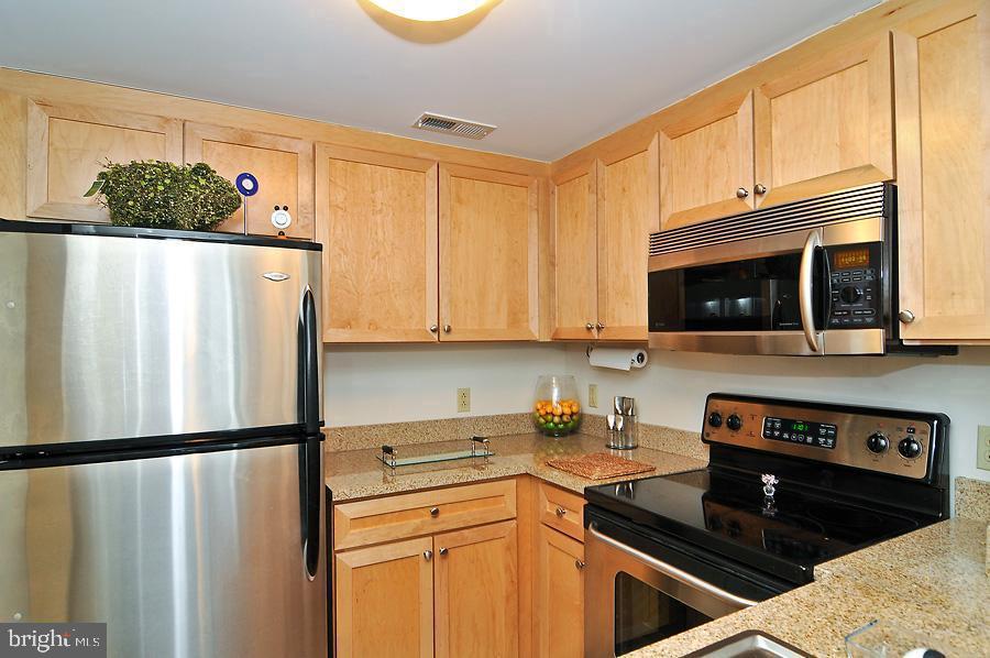1150 K Street Northwest, Unit 1305 Washington, DC 20005 - Photo 6 of 18 a kitchen with stainless steel appliances a refrigerator a stove a microwave and cabinets