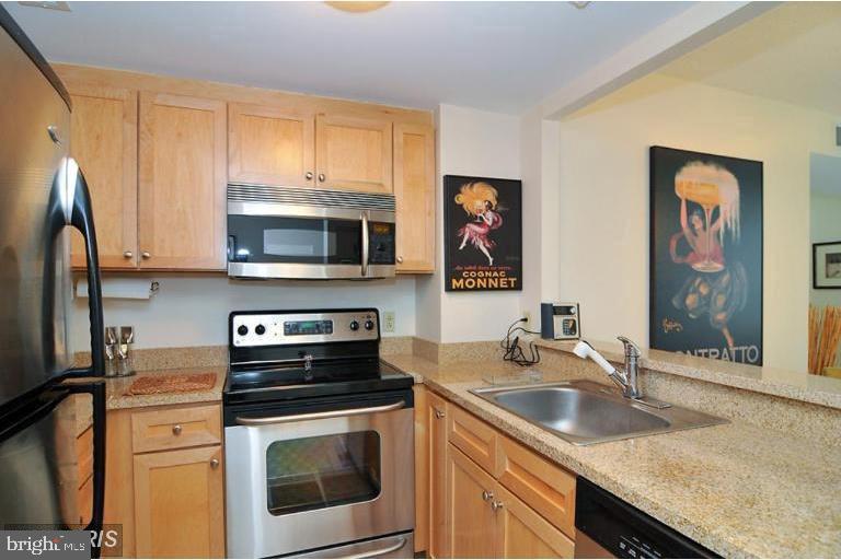 1150 K Street Northwest, Unit 1305 Washington, DC 20005 - Photo 7 of 18 a kitchen with stainless steel appliances granite countertop a stove microwave and sink