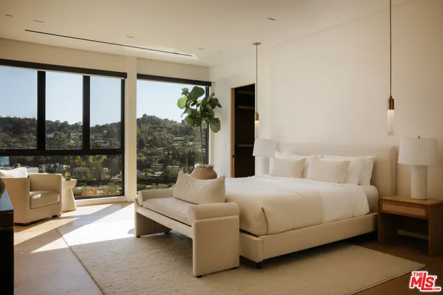 a bedroom with a bed and large window