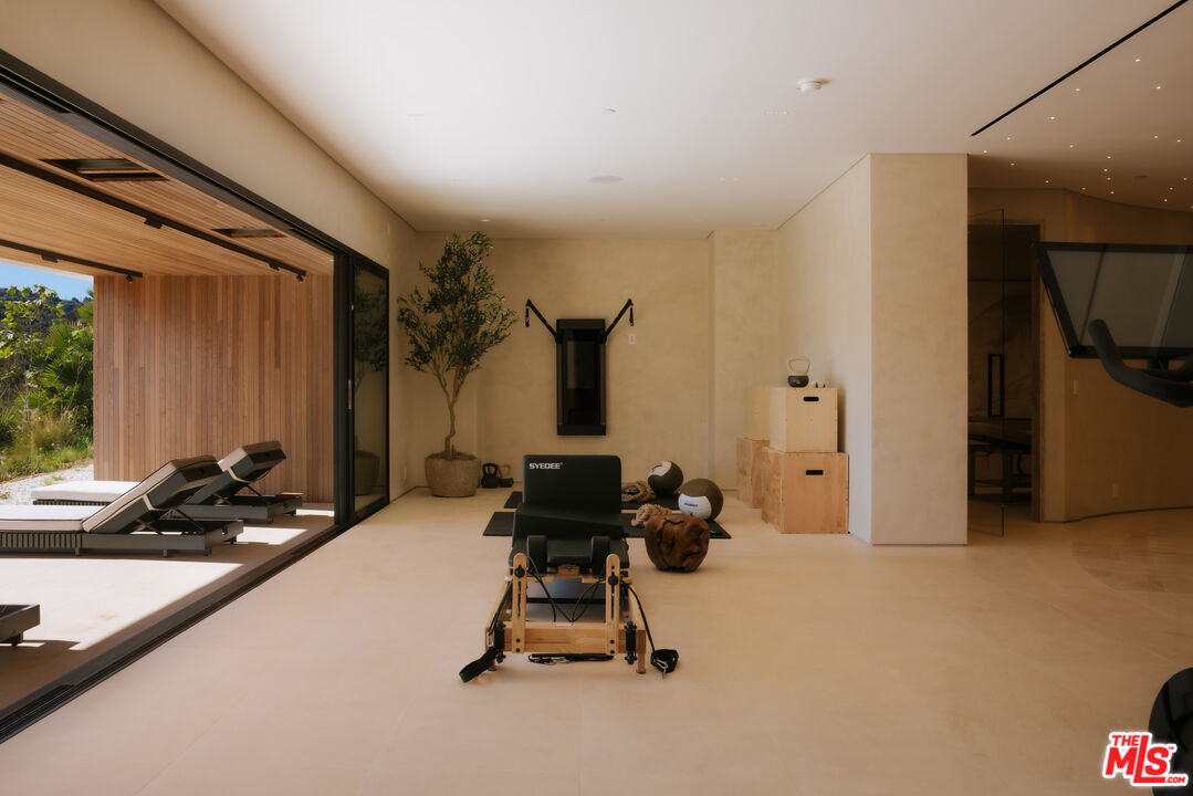 16187 Royal Oak Road Encino, CA 91436 - Photo 24 of 40 a room with gym equipment and a large window