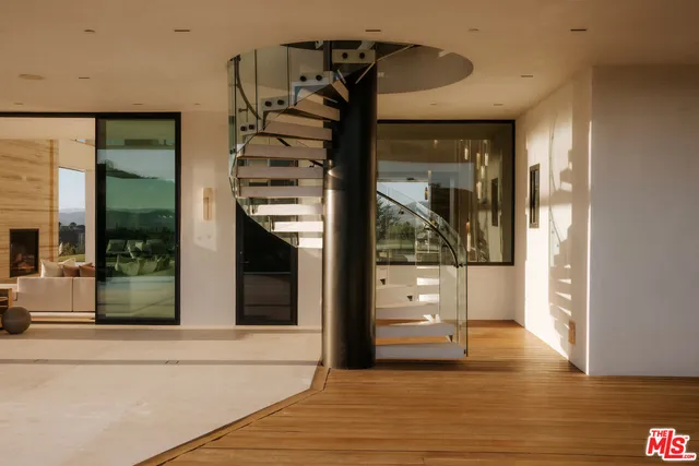 a view of a hallway with wooden floor and a living room