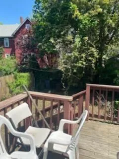 a view of a roof deck with couches and wooden floor