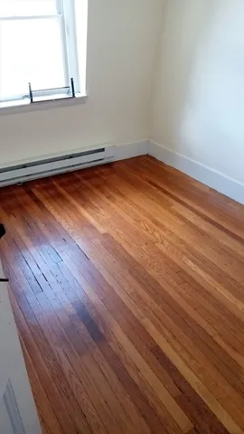 a view of a room with wooden floor and a window