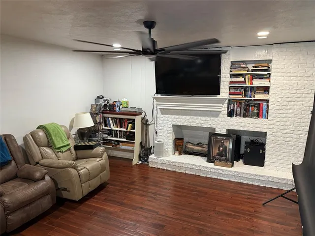 a living room with furniture a flat screen tv and a fireplace