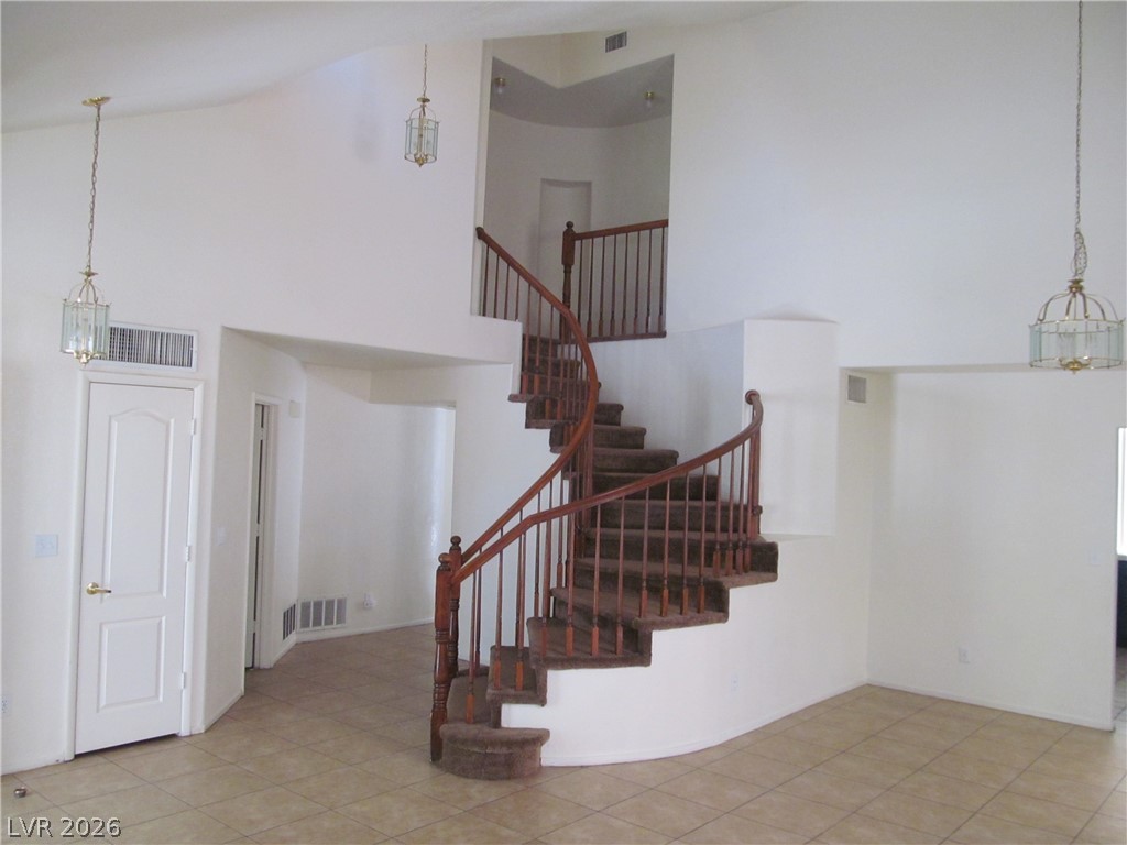 8701 Crescent Ridge Lane Las Vegas, NV 89134 - Photo 3 of 28 A grand, curving staircase provides a dramatic focal point in this high-ceilinged entry.