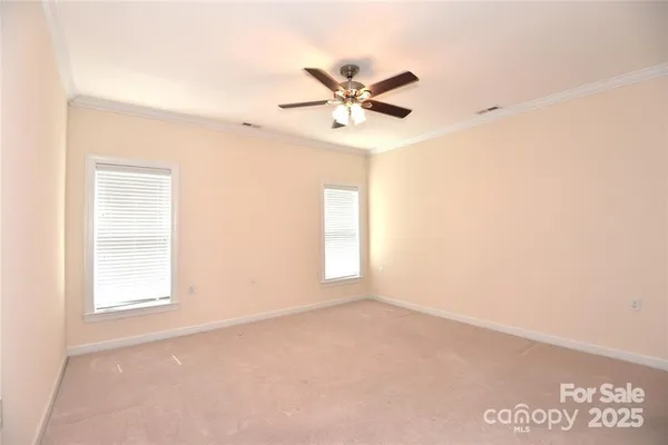 an empty room with windows and fan