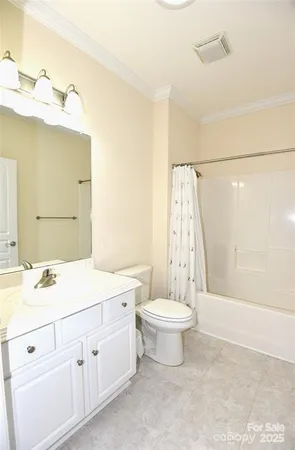 a bathroom with a double vanity sink a toilet a mirror and shower