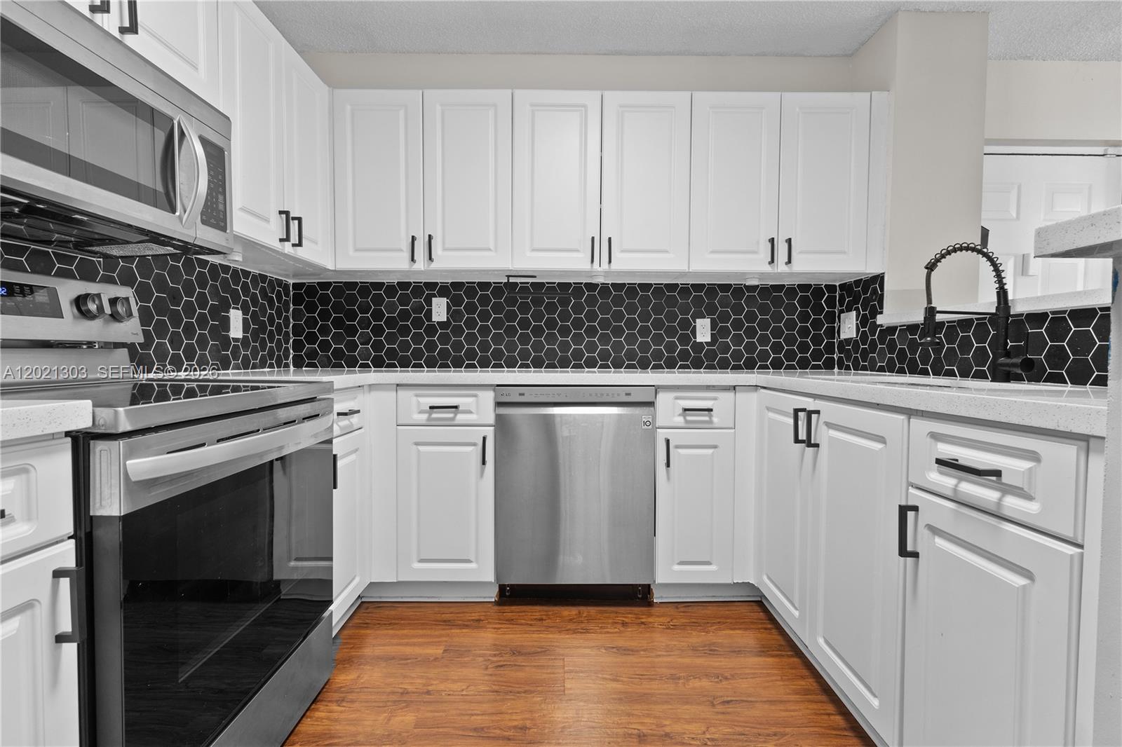 2123 Renaissance Boulevard, Unit 201 Miramar, FL 33025 - Photo 2 of 22 a kitchen with white cabinets and appliances