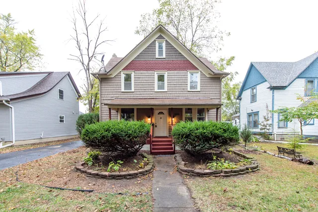 a front view of a house with a yard and potted plants
