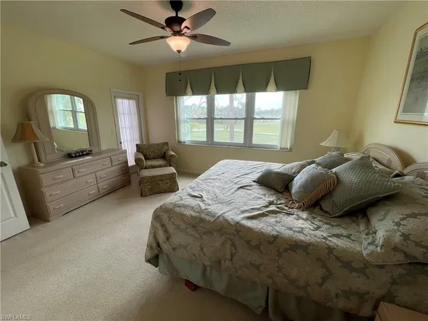 a bedroom with a bed couch and a large window
