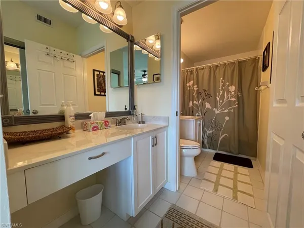 a bathroom with a granite countertop sink toilet and shower