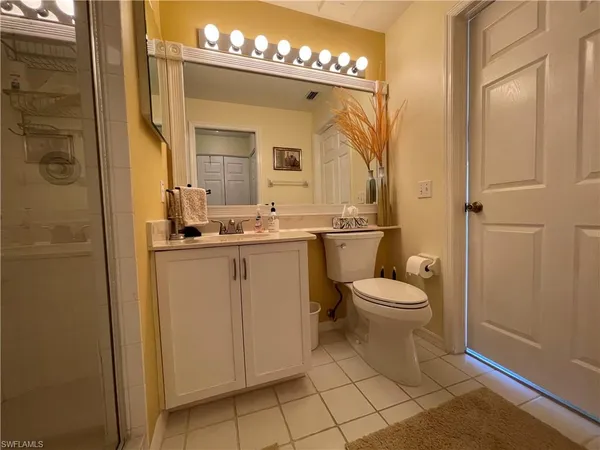 a bathroom with a toilet sink vanity and mirror