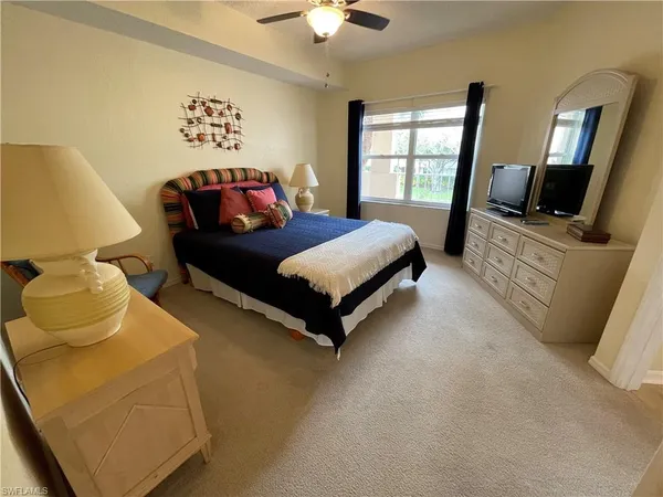 a spacious bedroom with a bed and a flat screen tv