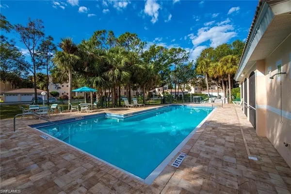 a view of a swimming pool with a garden and trees