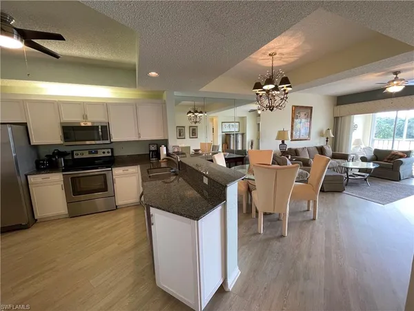 a large white kitchen with lots of counter space a sink and appliances