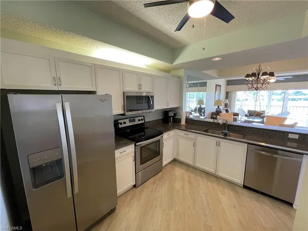 a kitchen with stainless steel appliances a refrigerator sink and microwave
