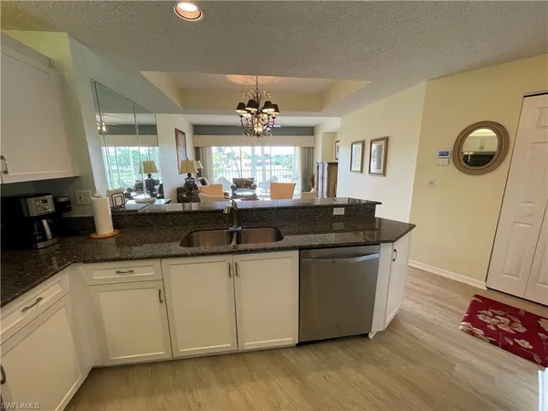 a view of living room with granite countertop furniture a sink a window and wooden floor