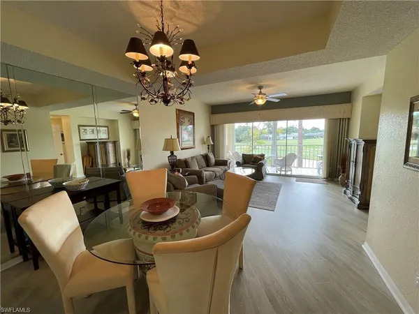 a living room with dining table furniture and a large window