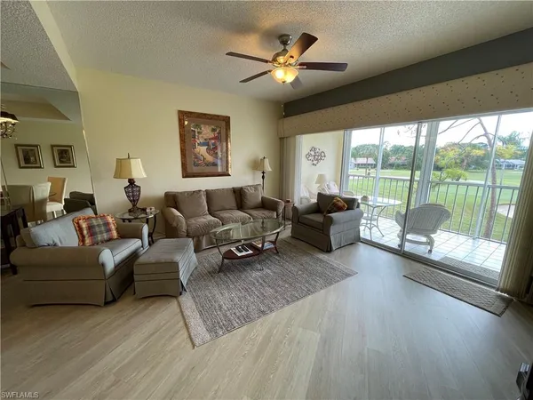 a living room with furniture and a large window with wooden floor