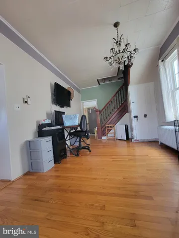 a view of a hallway with wooden floor and stairs