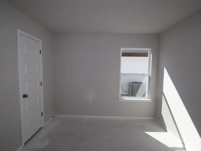 an empty room with windows and closet