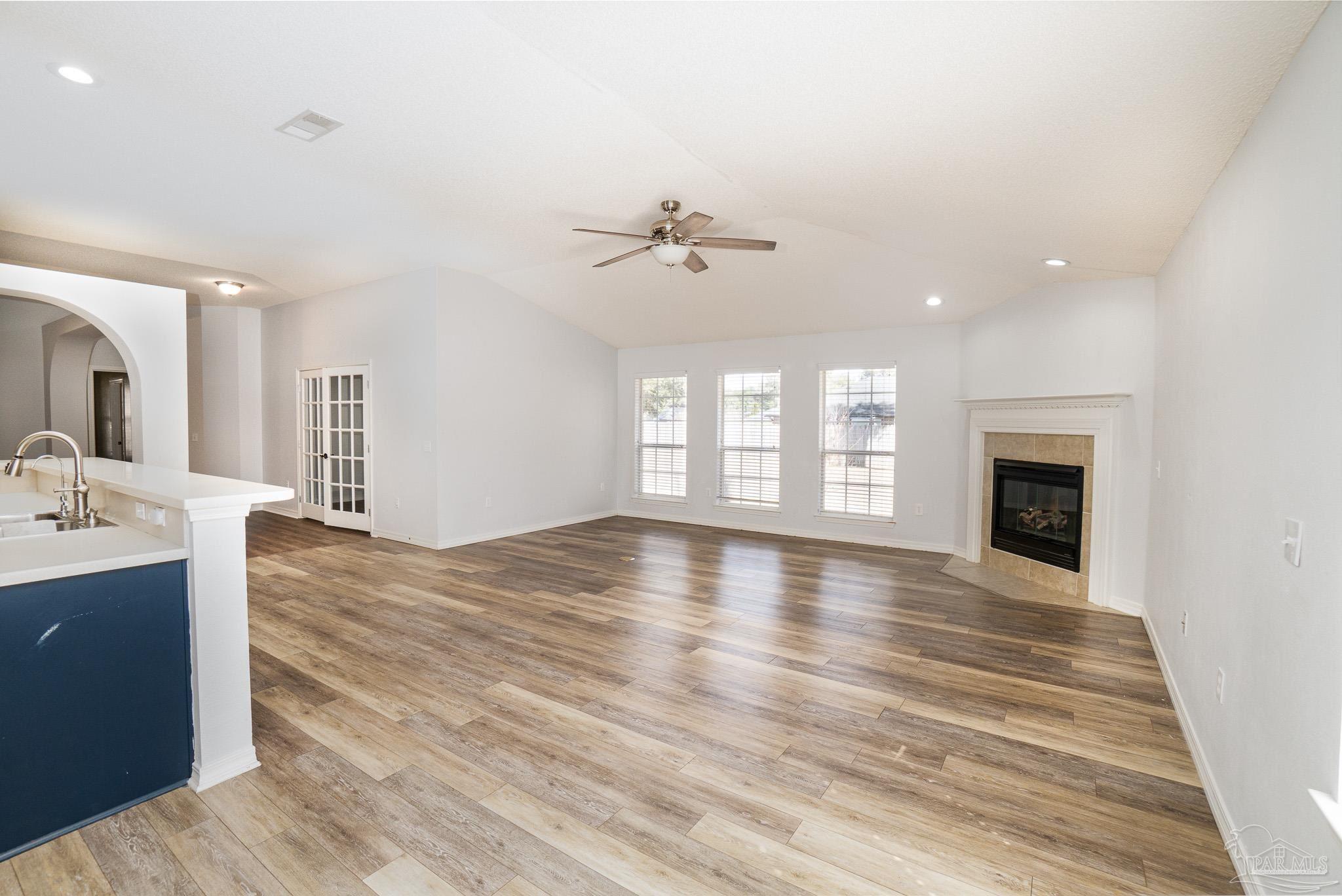 4836 Timber Ridge Drive Pace, FL 32571 - Photo 17 of 46 an empty room with wooden floor and a fireplace