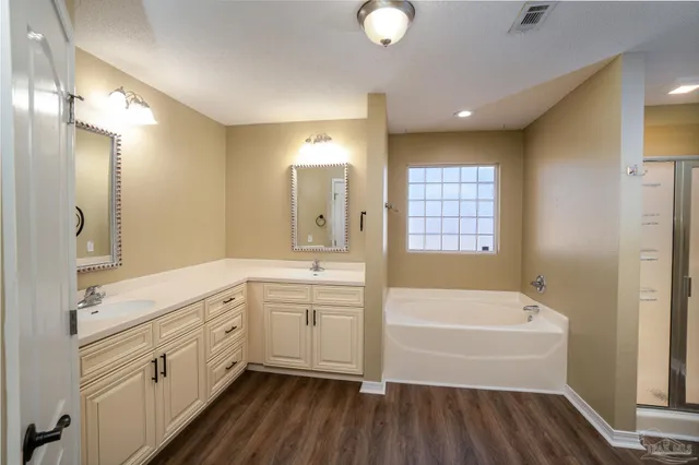 a bathroom with a tub sink shower and mirror