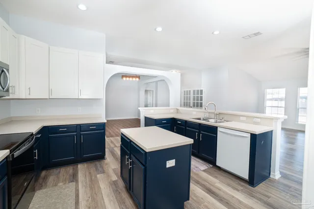 a kitchen with a stove top oven sink and cabinets