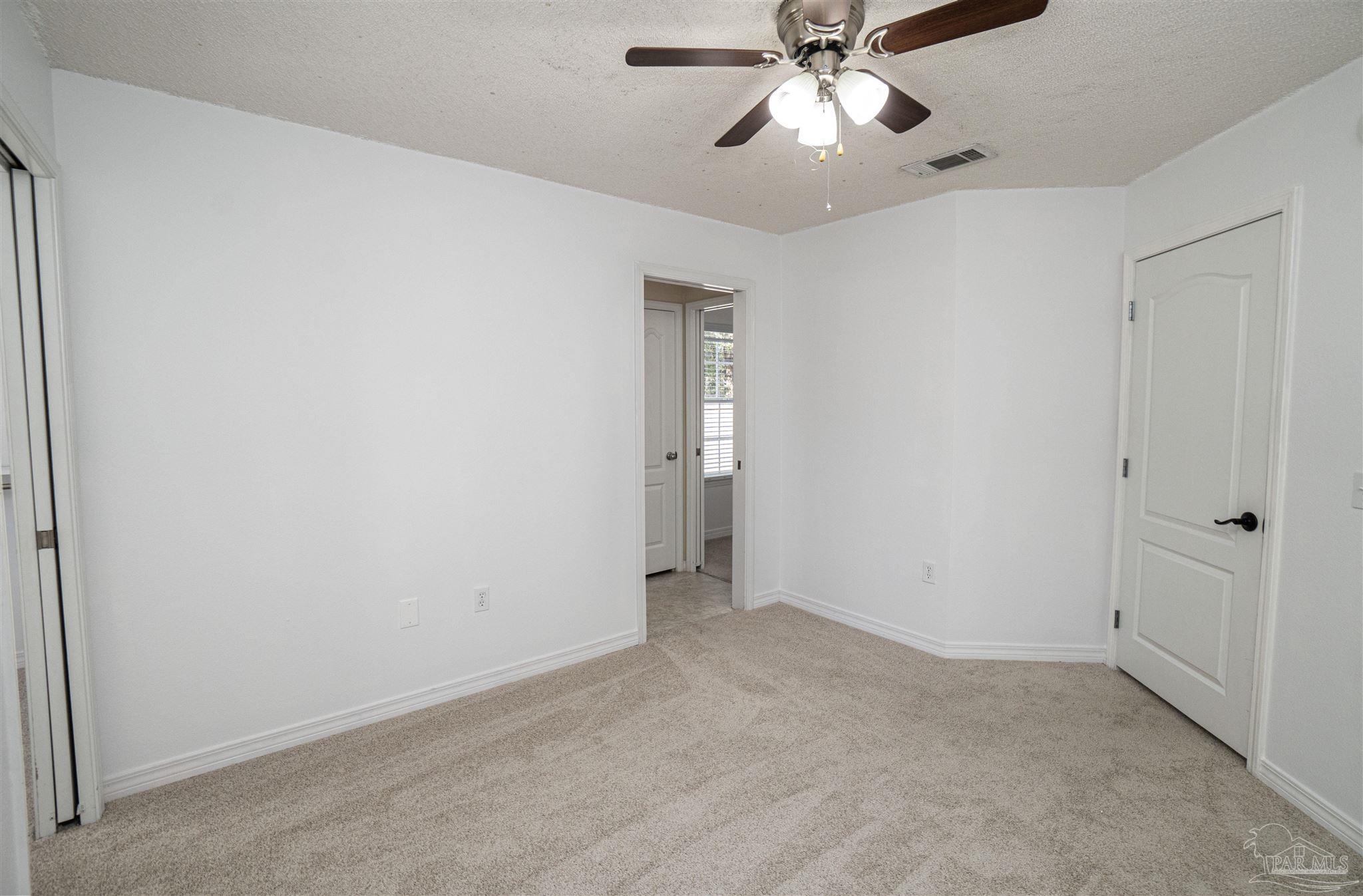 4836 Timber Ridge Drive Pace, FL 32571 - Photo 23 of 46 a view of an empty room and chandelier fan