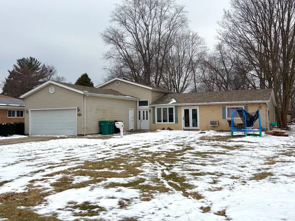 a view of a house with a yard covered in snow