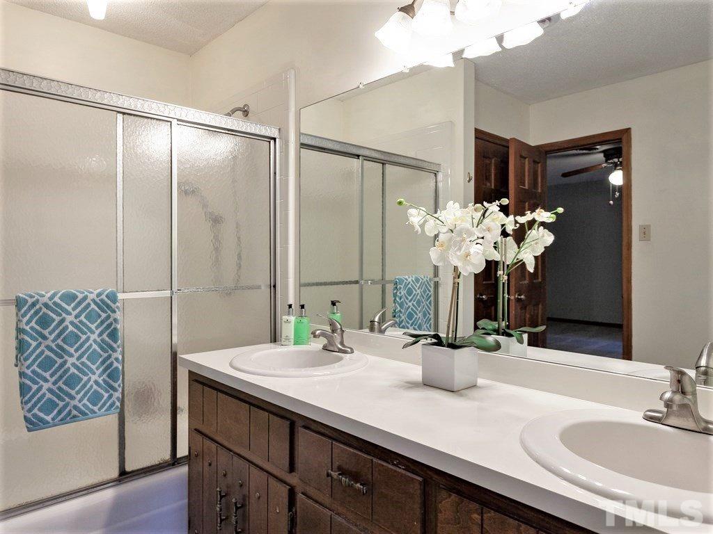 3208 Brennan Drive Raleigh, NC 27613 - Photo 14 of 25 a bathroom with a double vanity sink and a mirror