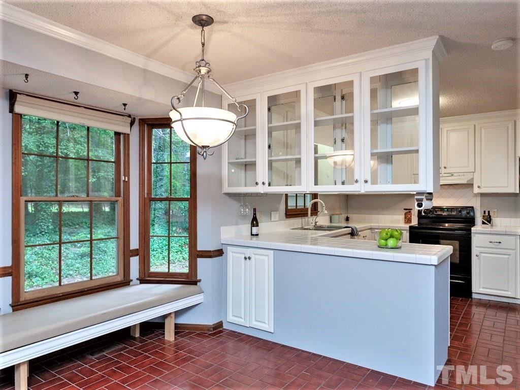 3208 Brennan Drive Raleigh, NC 27613 - Photo 5 of 25 a kitchen with stainless steel appliances granite countertop sink stove and cabinets