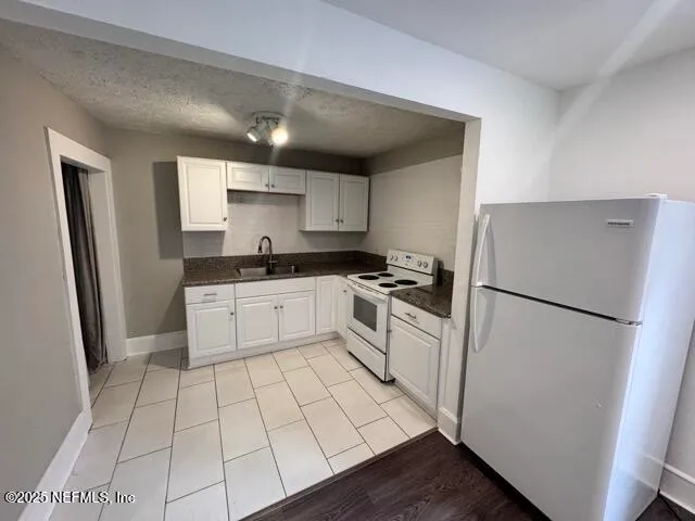 a kitchen with white cabinets and white appliances