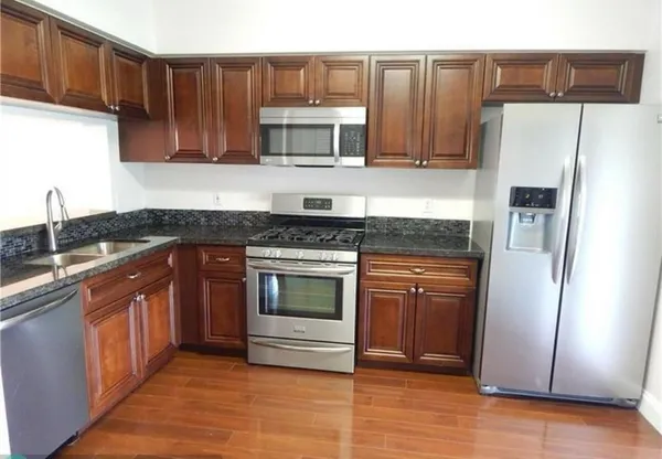 a kitchen with granite countertop wooden cabinets and stainless steel appliances