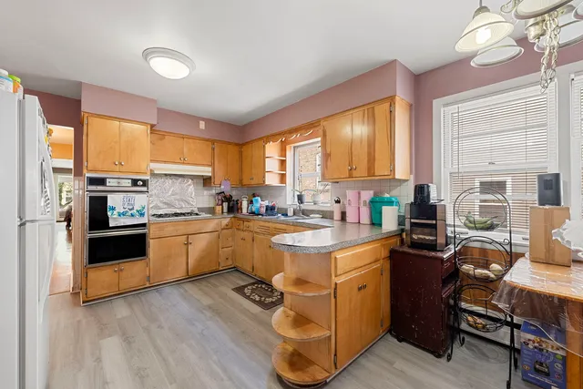 a kitchen with a sink appliances cabinets and a window