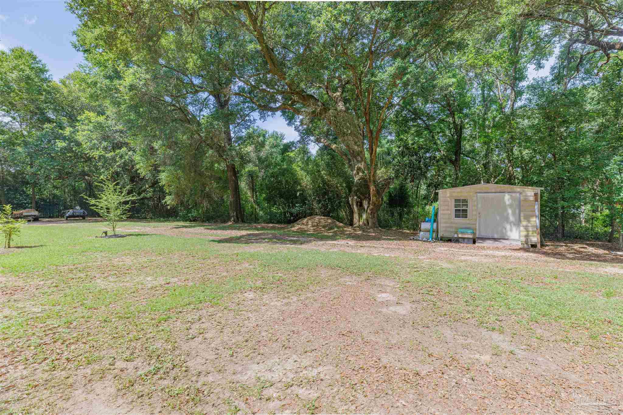 5049 Guernsey Road Pace, FL 32571 - Photo 60 of 61 a backyard of a house with lots of green space