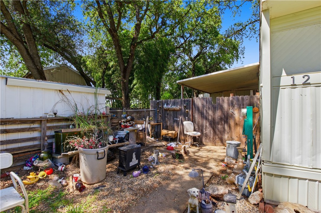 2465 Palermo Road, Unit 12 Palermo, CA 95968 - Photo 16 of 18 a view of a patio with table and chairs potted plants and large tree
