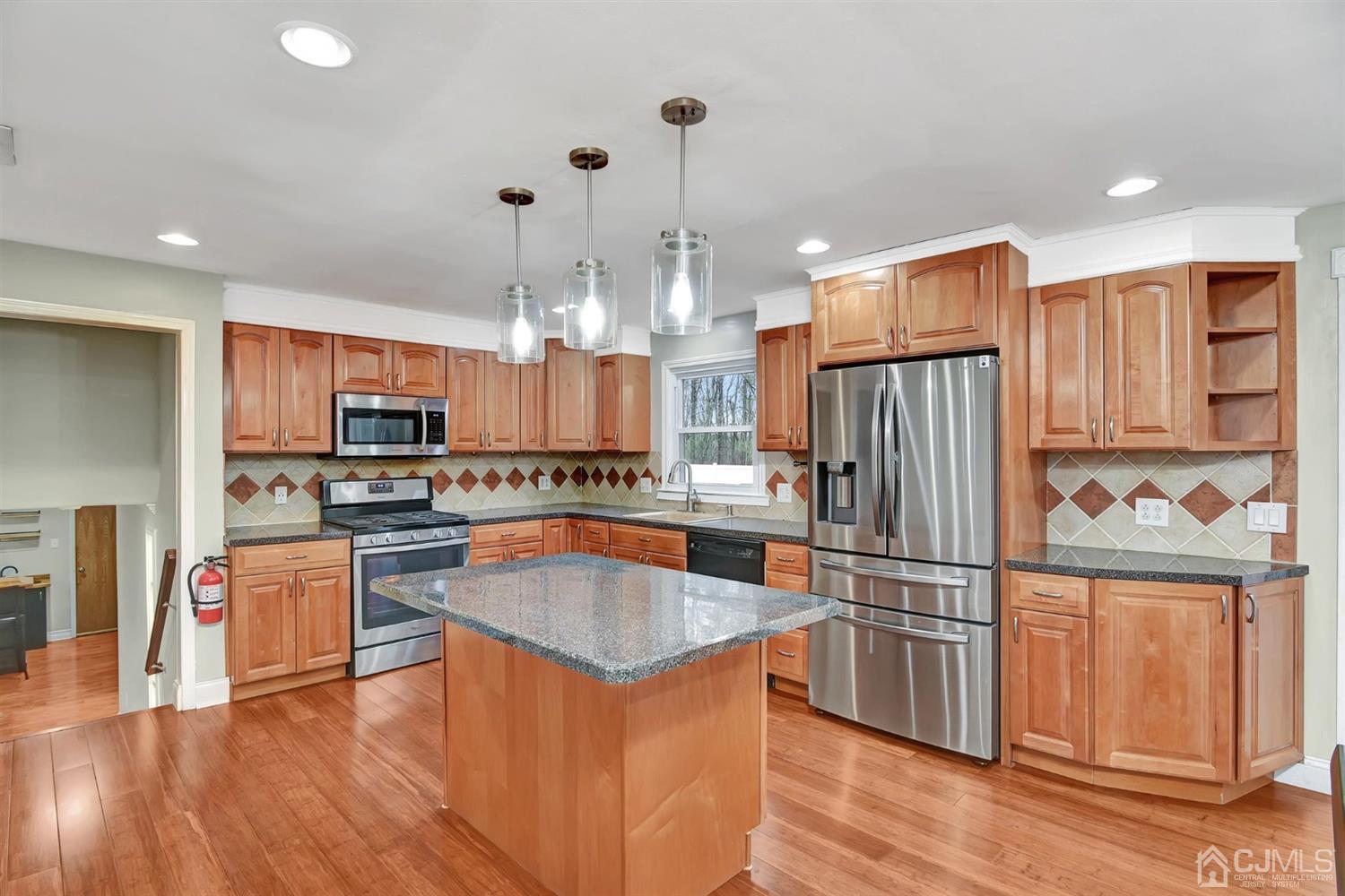 423 Ridge Road Dayton, NJ 08810 - Photo 12 of 29 a kitchen with stainless steel appliances granite countertop a refrigerator a stove top oven and a center island