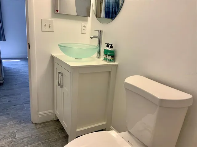 a bathroom with a granite countertop toilet and a sink