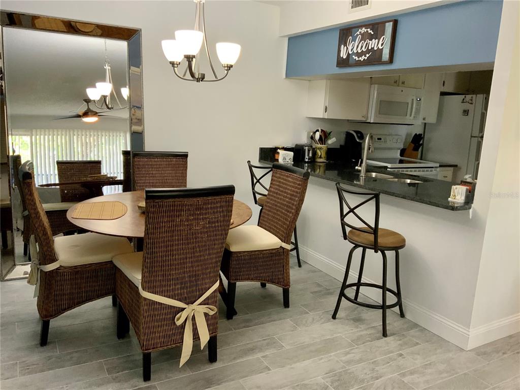 3213 South Beneva Road, Unit 204 Sarasota, FL 34232 - Photo 7 of 18 a dining room filled chandelier and wooden floor
