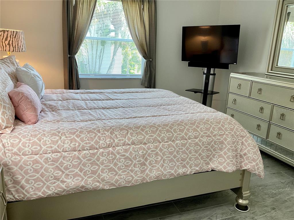 3213 South Beneva Road, Unit 204 Sarasota, FL 34232 - Photo 9 of 18 a bedroom with a bed and a flat screen tv