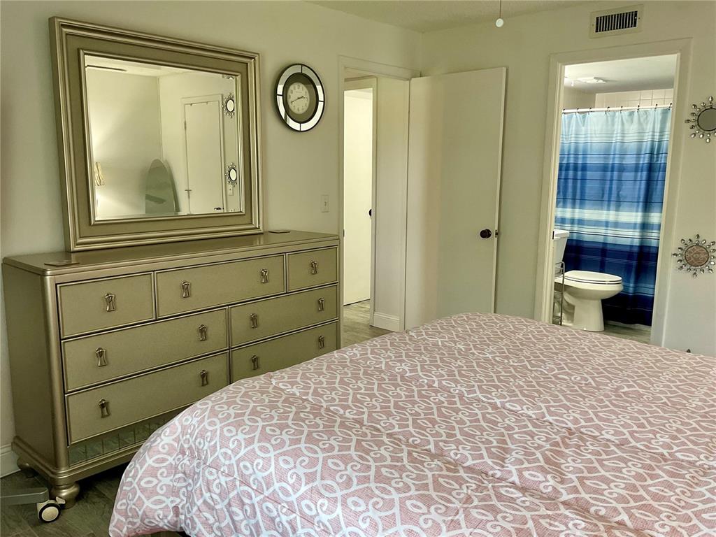 3213 South Beneva Road, Unit 204 Sarasota, FL 34232 - Photo 10 of 18 a bedroom with a bed and a mirror on the dresser