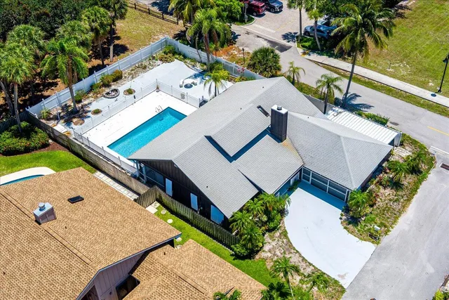 an aerial view of a house with a yard and trees all around