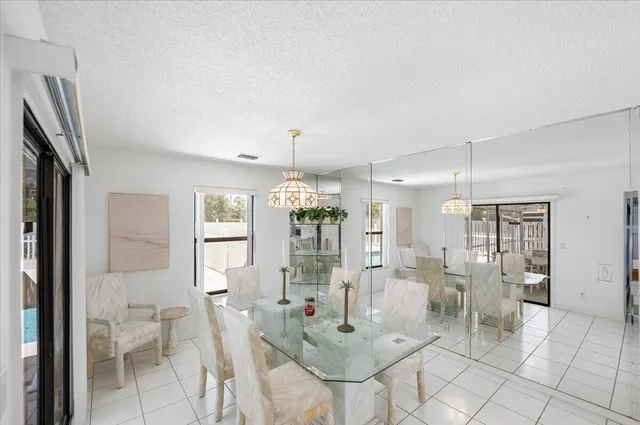 a bedroom with a bed a mirror on dresser and a chandelier