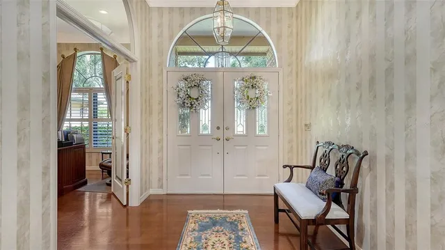 a view of a dining room with furniture a chandelier and wooden floor
