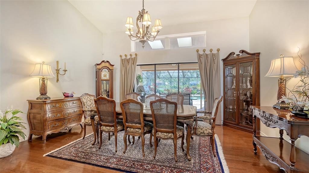 7426 Weeping Willow Boulevard Sarasota, FL 34241 - Photo 14 of 66 a view of a dining room with furniture a chandelier and wooden floor
