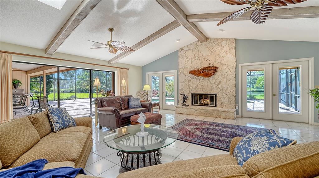 7426 Weeping Willow Boulevard Sarasota, FL 34241 - Photo 17 of 66 a living room with furniture a fireplace and a chandelier
