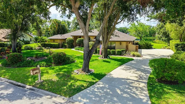 a view of a house with a big yard and large trees