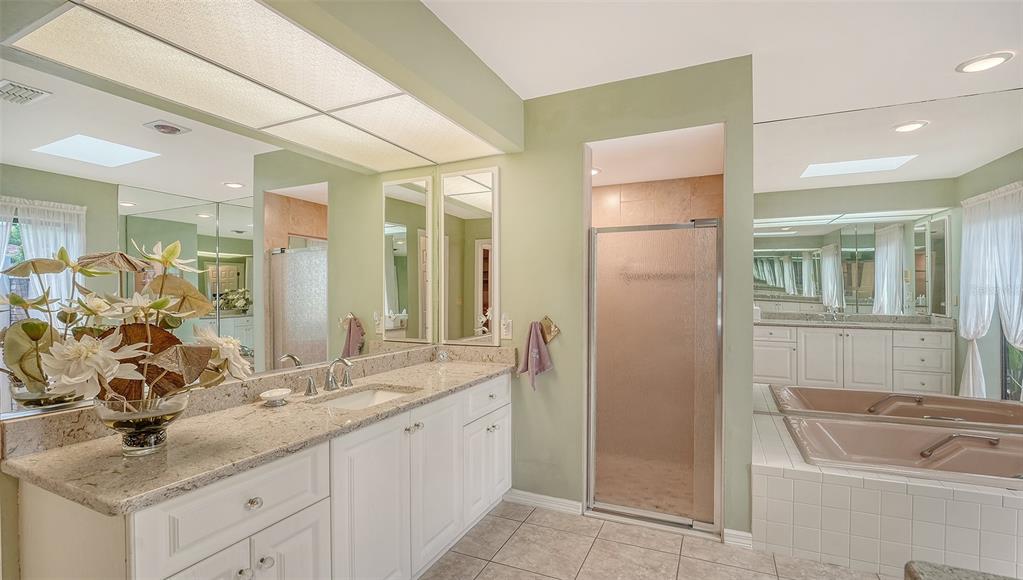 7426 Weeping Willow Boulevard Sarasota, FL 34241 - Photo 33 of 66 a bathroom with a granite countertop sink a mirror and a shower