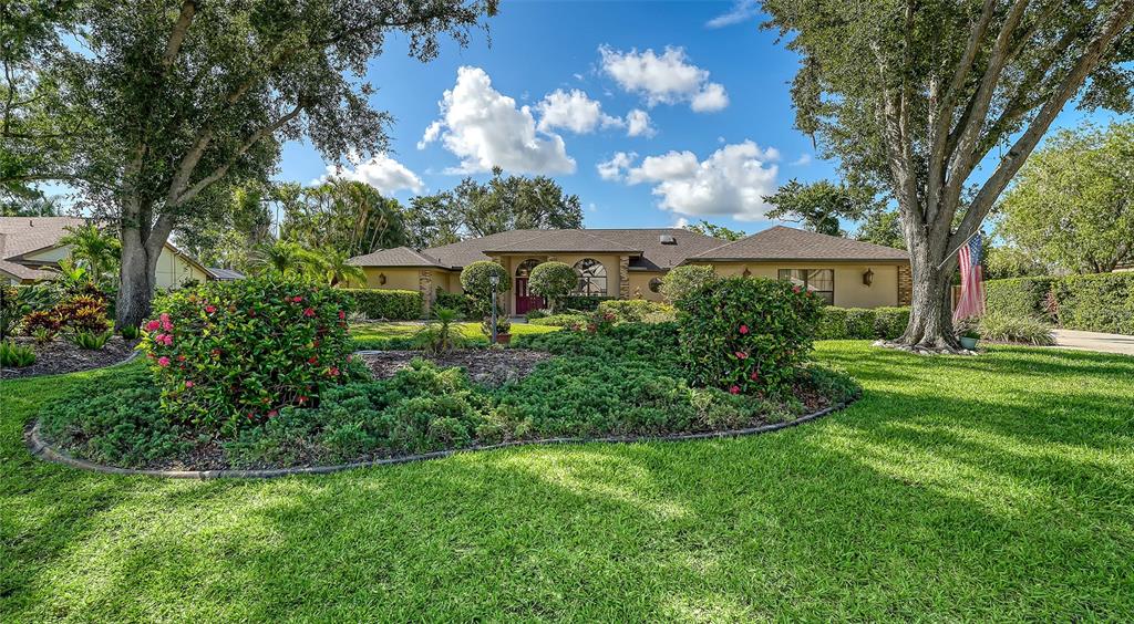 7426 Weeping Willow Boulevard Sarasota, FL 34241 - Photo 4 of 66 a view of a house with a big yard and large trees